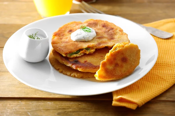 Stack of corn tortillas with stuffing and glass of juice on wooden table background — Stock Photo, Image