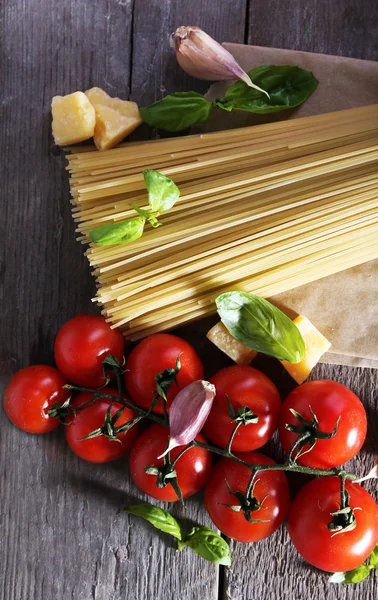 Pasta met cherry tomaten en andere ingrediënten op houten tafel achtergrond — Stockfoto
