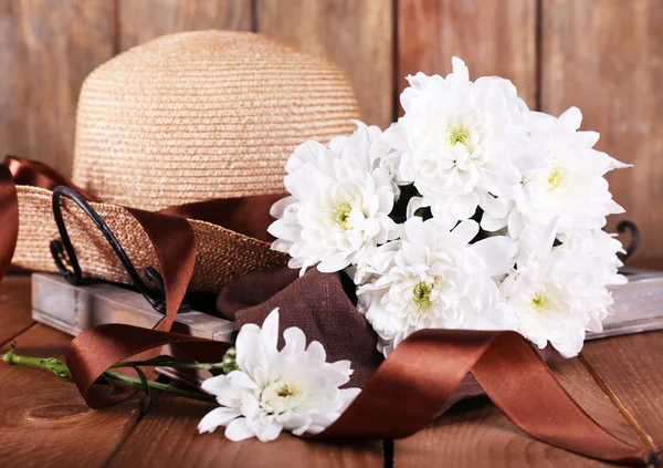 Hut mit Blumen auf Holzgrund — Stockfoto