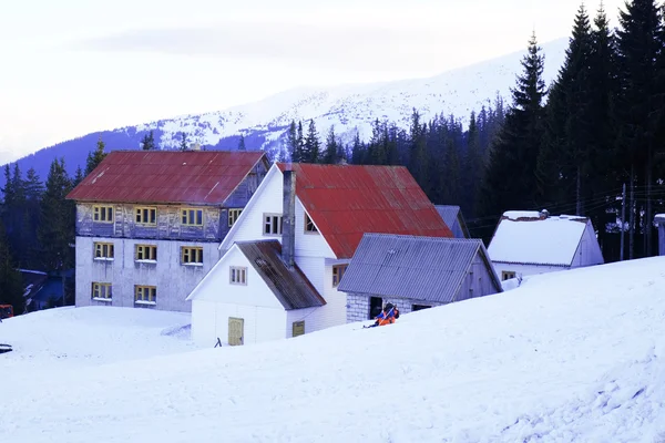 Здание с красной крышей над снегом и Карпатами зимой — стоковое фото