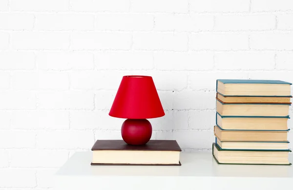 Trähylla med böcker och lampa på tegel vägg bakgrund — Stockfoto