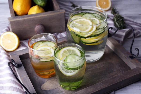 Frischwasser mit Zitrone und Gurke im Glas in Holzschale, Nahaufnahme — Stockfoto