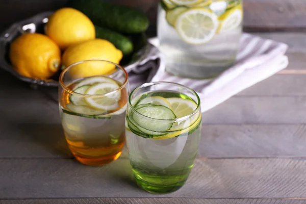 레몬과 오이 나무 배경에 유리에 신선한 물 — 스톡 사진