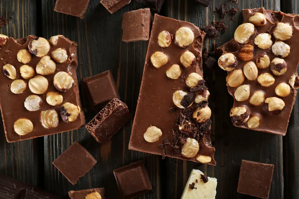 Uppsättning av choklad med hasselnötter på träbord, ovanifrån — Stockfoto