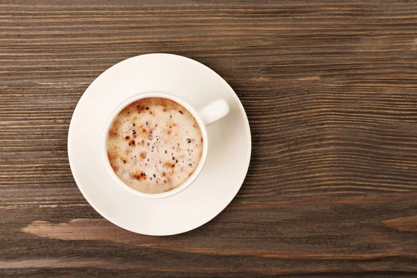 Secangkir kopi di atas meja kayu, pemandangan atas — Stok Foto