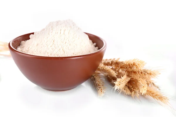 Farinha branca em tigela e espigas de trigo isoladas em branco — Fotografia de Stock