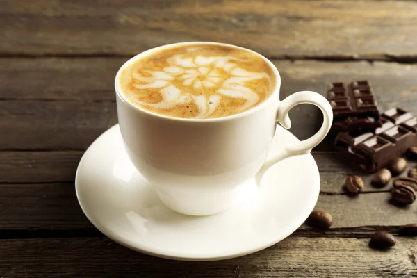 Filiżanka do kawy latte art z ziaren i czekolady na drewniane tła — Zdjęcie stockowe