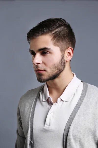 Portrét mladého muže na šedém pozadí — Stock fotografie