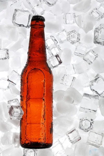 Glazen flesje bier op ijs kubussen achtergrond — Stockfoto
