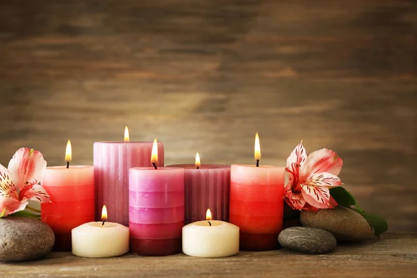 Beautiful composition with candles and spa stones on wooden background — Stock Photo, Image