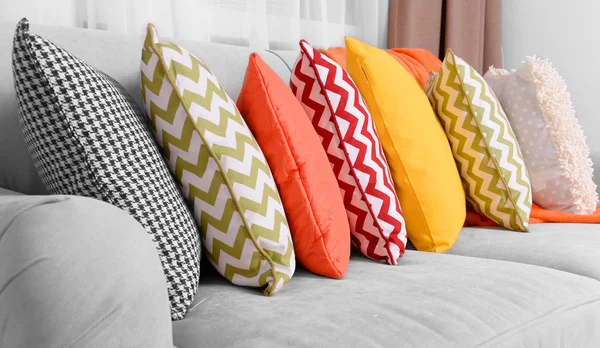 Диван с красочными подушками в номере — стоковое фото