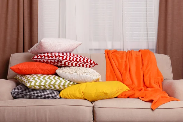 Sofá con almohadas de colores en la habitación — Foto de Stock