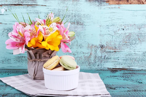 Delicioso macarrón con hermosas flores sobre fondo de madera —  Fotos de Stock