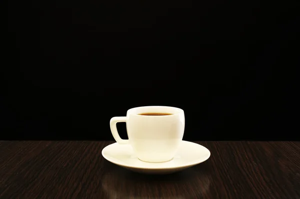 Šálek kávy na dřevěném stole — Stock fotografie