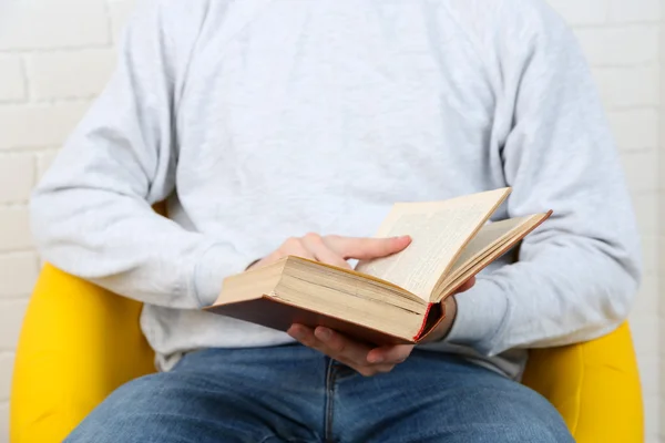 Jonge man lezen boek, close-up, op lichte achtergrond — Stockfoto