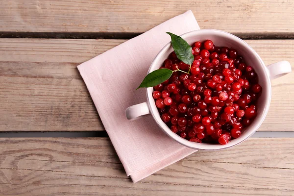 Red currant in bowl on wooden background — Stock Photo, Image