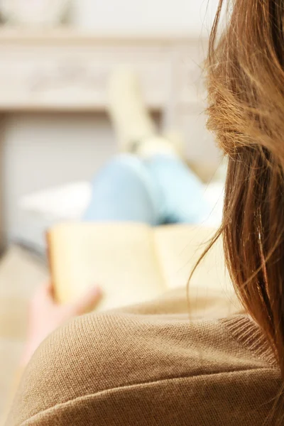 Vrouw lezen boek op sofa in kamer — Stockfoto