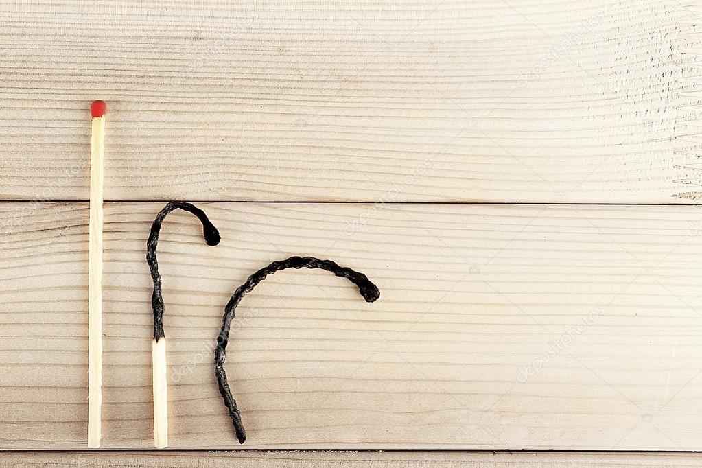 Burnt matches and whole one on wooden background