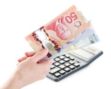 Female hand with Canadian dollars and calculator, isolated on white clipart