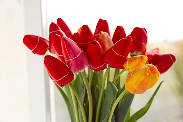 Kytice z čerstvých tulipánů na parapetu pozadí — Stock fotografie