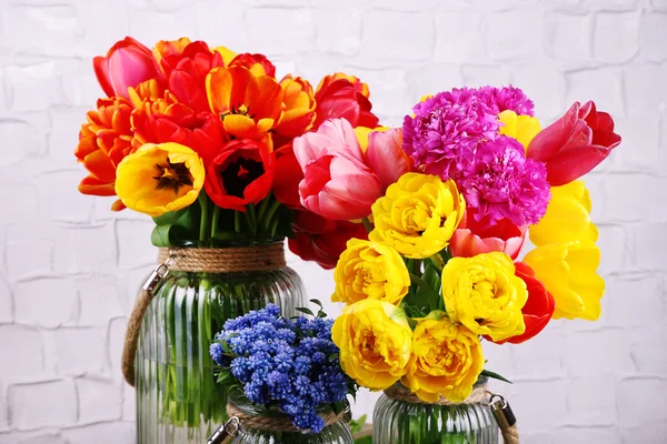 Mooie bloemen in vazen op muur achtergrond — Stockfoto