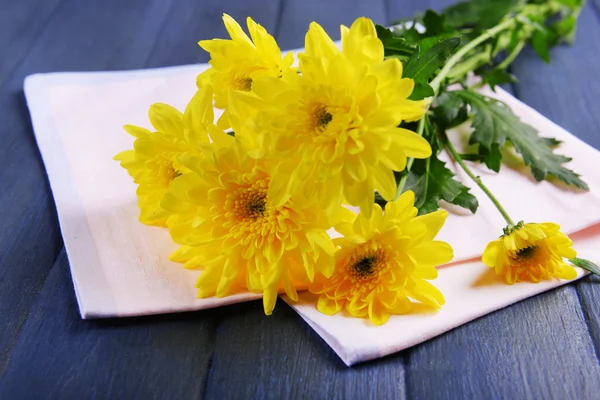 Mooi boeket van gele chrysanten met servet op houten tafel — Stockfoto