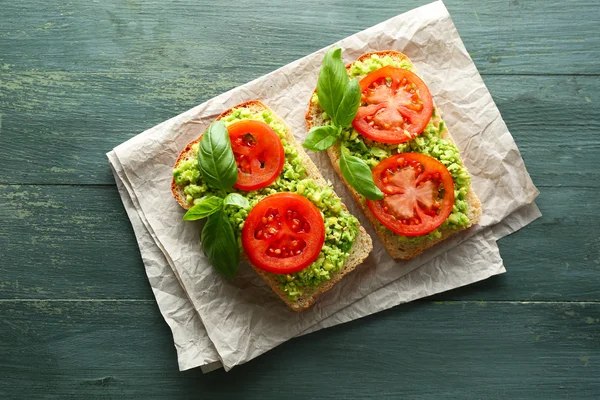 Vegansk smörgås med avokado och grönsaker på trä bakgrund — Stockfoto