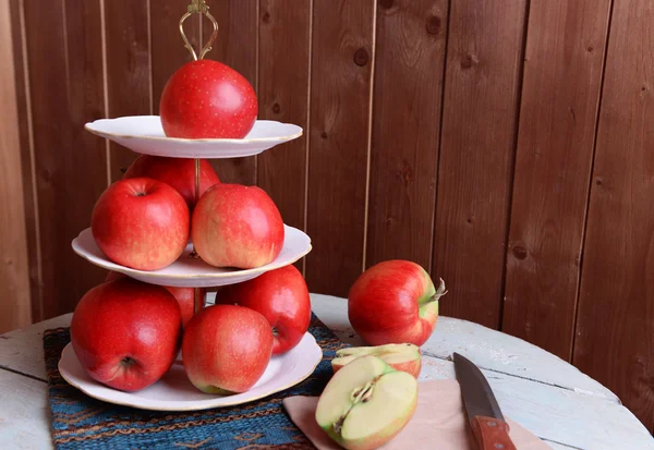 Leckere reife Äpfel auf Serviertablett auf Holzuntergrund — Stockfoto