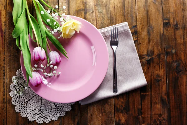 Vajilla con flores en la mesa — Foto de Stock