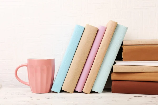Bücher und Tasse im Holzregal — Stockfoto
