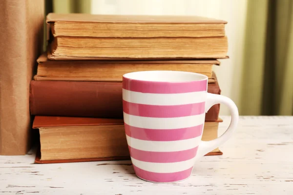 Knihy a pohár na dřevěný stůl — Stock fotografie