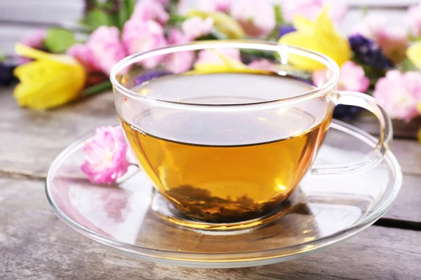 Cup of herbal tea with flowers on wooden background — Stock Photo, Image