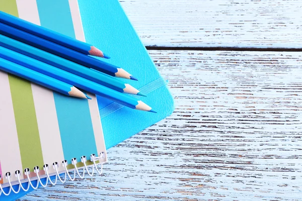 Turquoise kleurpotloden en dagboek op houten tafel, close-up — Stockfoto