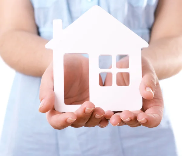 Mani femminili con piccolo modello di casa isolato su bianco — Foto Stock