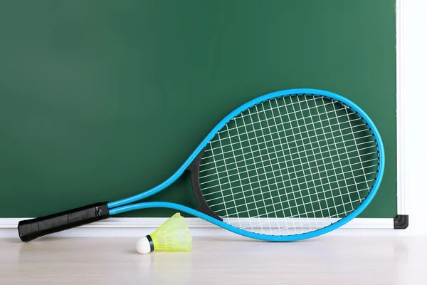 Tennisschläger und Federbälle auf Tafel-Hintergrund — Stockfoto