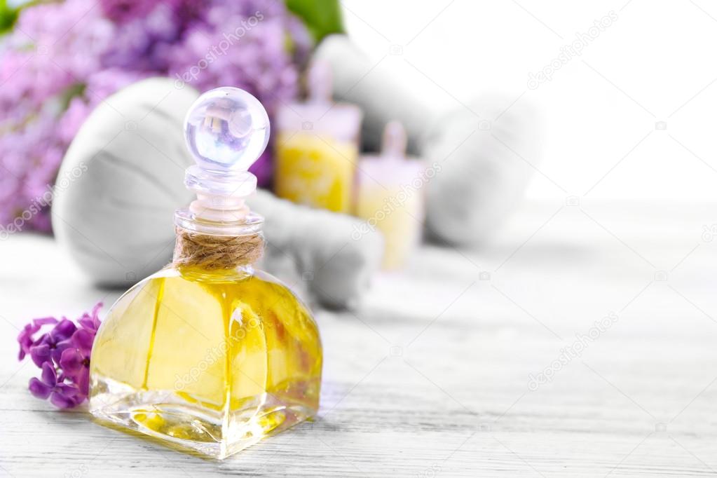 Sea salt, flowers and spa treatment on color wooden table, on light background