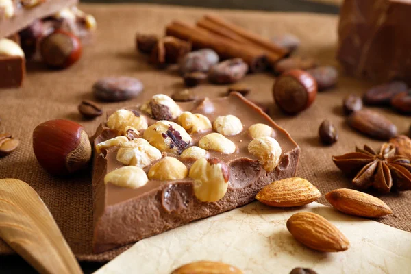 Delicious chocolates with nuts spices on table, closeup — Stock Photo, Image