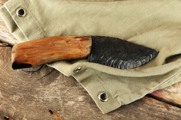 Hunting knife on wooden table with sackcloth, closeup — Stock Photo, Image