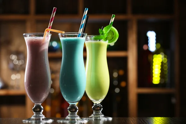 Glasses of fruit cocktails in bar on bright blurred background — Stock Photo, Image