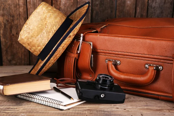 Packing suitcase for trip on wooden background — Stock Photo, Image