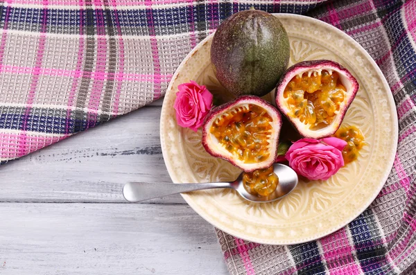 Плод страсти на тарелке на цветном деревянном фоне — стоковое фото