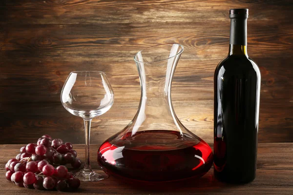 Glass carafe of wine on wooden background — Stock Photo, Image