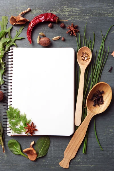 Libro di ricette aperto con erbe fresche e spezie su sfondo di legno — Foto Stock