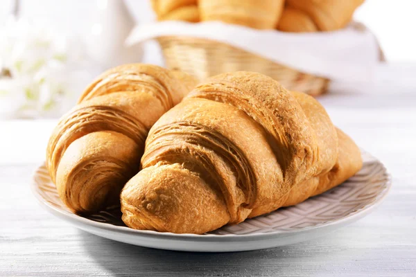 Läckra croissanter på tallriken på bordet närbild — Stockfoto
