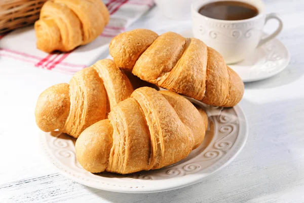 Deliciosos croissants na placa na mesa close-up — Fotografia de Stock