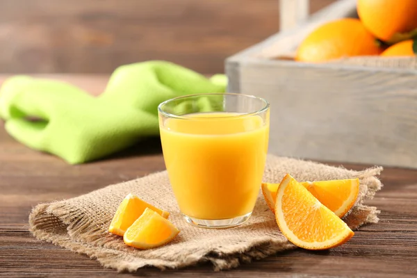 Orangensaft auf Tisch auf Holzgrund — Stockfoto