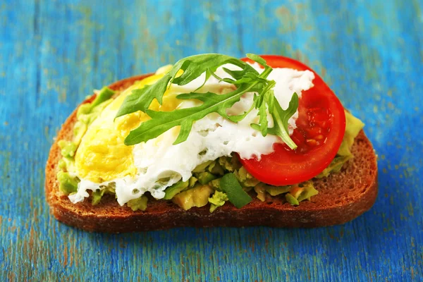 Tasty sandwich with egg, avocado and vegetables on wooden background — Stock Photo, Image