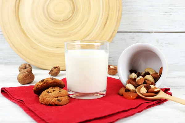 Melk in glaswerk met walnoten en cookies op houten tafel, close-up — Stockfoto