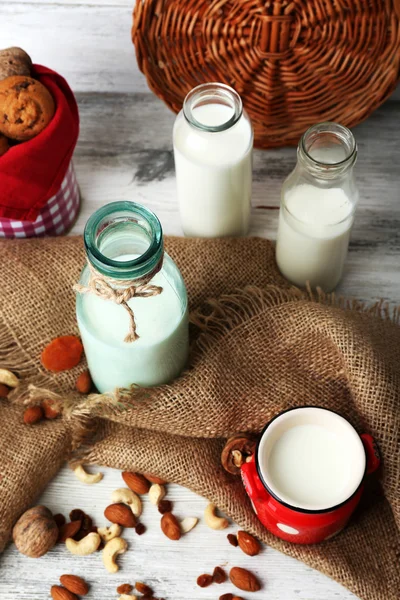 Mjölk i glas och valnötter på träbord med säckväv, närbild — Stockfoto