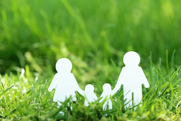 Cutout family over green grass background — Stock Photo, Image